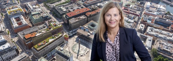 Maria Björklund framför en flygbild över Urban Escape. Obs. Bilden är ett montage.